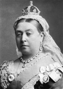 Black-and-white portrait of Queen Victoria wearing royal regalia, including a crown, veil, and ornate jewelry.