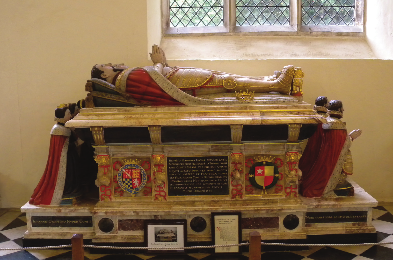 Image of a tomb. A man lays across the tomb in a praying position. Around the tomb are praying figures.