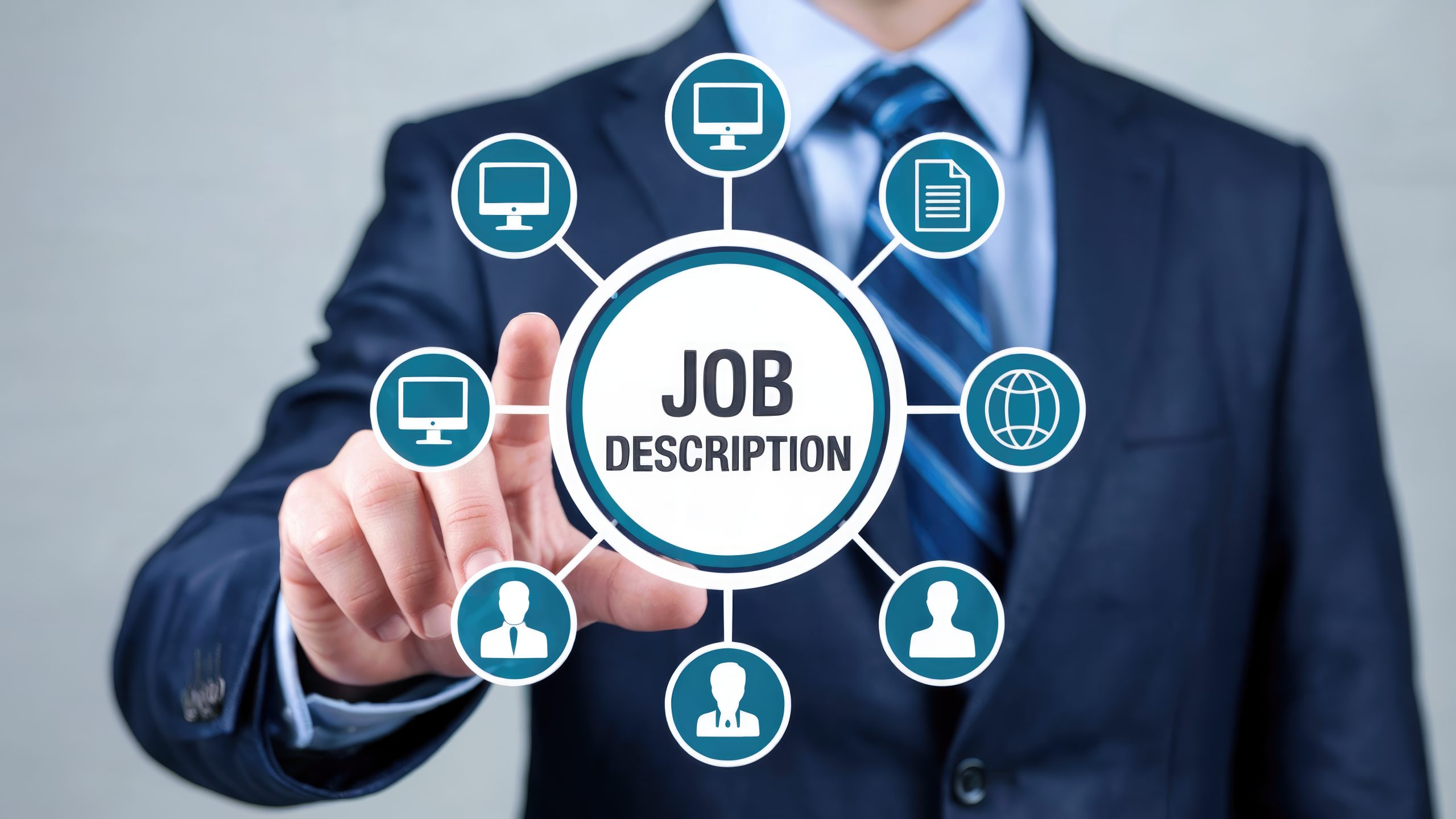 A man dressed in a suit points to a circle with the words Job Description surrounded by various icons such as computers, paper, people and the internet. Adobe Stock I