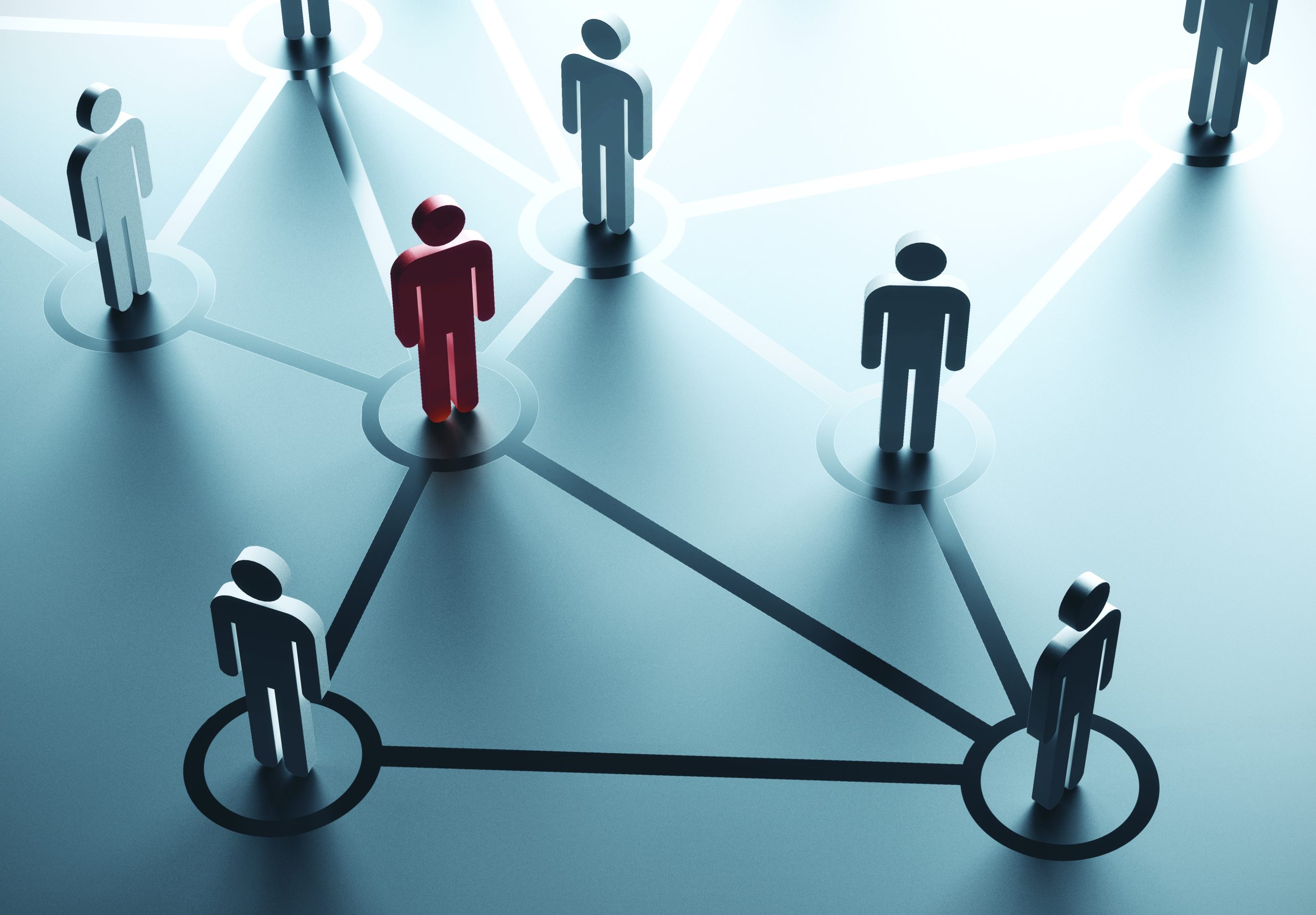 Stick figures of people stand on a table with lines drawn between them showing the network between them. Adobe Stock Image